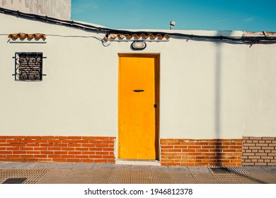 humble house with a white front and a yellow wooden door - Powered by Shutterstock