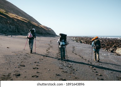 Humboldt County, CA, USA - May 23 2020: Three Backpackers Hiking The Lost Coast Trail. 