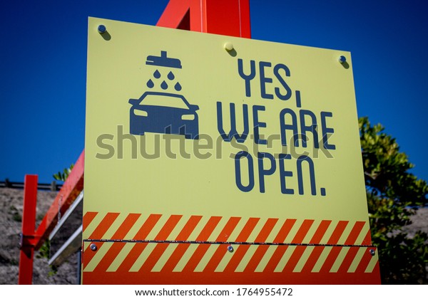 Humerous COVID-19 related sign at car wash stating Yes\
We Are Open 