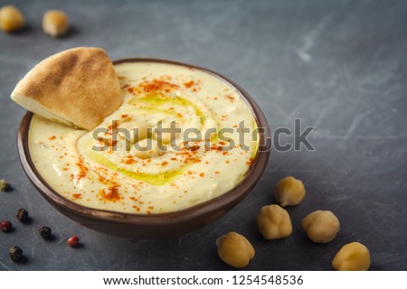 Hummus in a bowl and pita bread on grey background. Mediterranean snack, vegetarian healthy food concept. Top view, flat lay, copy space. Stok fotoğraf © 