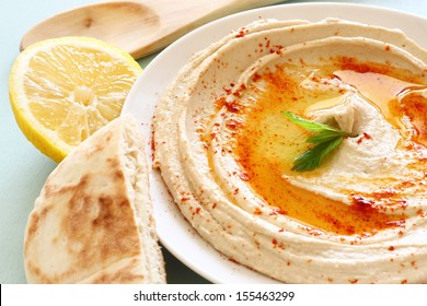 Hummus Dip Plate And Lemon On Wooden Table 