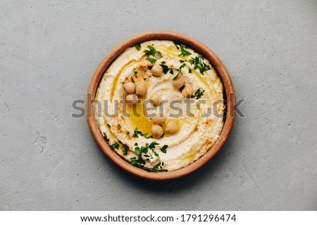 Hummus. Large bowl of homemade hummus garnished with chickpeas, red sweet pepper, parsley and olive oil, flat lay, middle east food Stok fotoğraf © 
