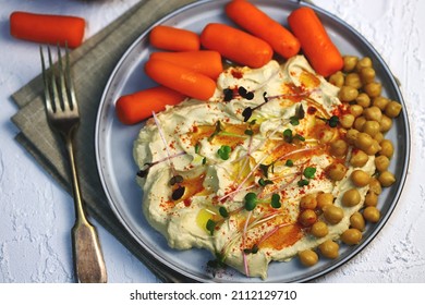 Hummus With Olive Oil And Baby Carrots On A Plate.