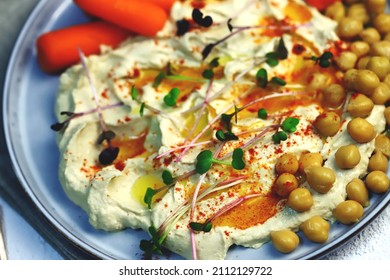 Hummus With Olive Oil And Baby Carrots On A Plate.