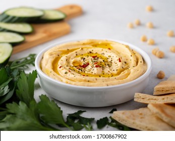 Hummus plate with cucumber slices and parsley - Shutterstock ID 1700867902