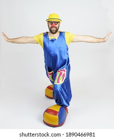 Humor And Fun Concept. A Clown In A Bright Suit Stretched Out His Arms In Different Directions