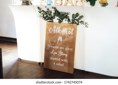 Humorous board about alcohol and love story. White wall background. Wedding day concept.