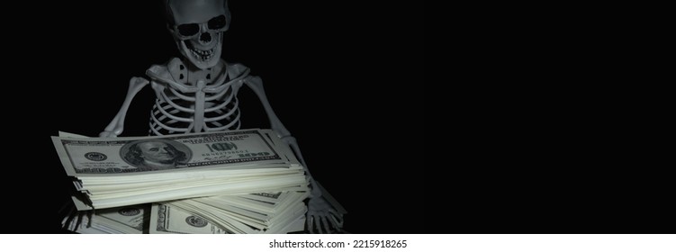 Humorous conceptual image of skeleton skull with US Dollar money as symbol of wealth and greed. Copy space.