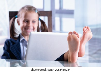 Humorales Foto von glücklicher, kinderfreundlicher Geschäftsfrau ruht und arbeitet gleichzeitig. Selektiver Fokus auf bloße Füße. 