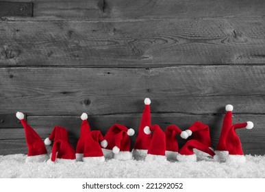 Humorously red, grey and white wooden christmas background with santa hats.