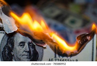 A hundred dollar bill in American US currency is on fire - Powered by Shutterstock