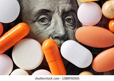 Hundred dollar bill covered with colorful medical pills. Money, healthcare and drug trafficking concept. Macro, top down view.  - Powered by Shutterstock
