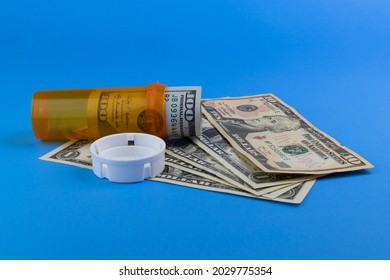 Hundred Dollar Bill And Smaller Dollar Bills With A Pill Bottle Representing The High Cost Of Drug And Opiate Addiction.