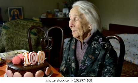 A Hundred Years Old Woman On Her Birthday, Blowing The Candles On Her Cake