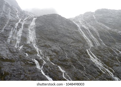 Hundreds of waterfalls flowing from the mountains during the rainstorm in Fiordland National Park, New Zealand