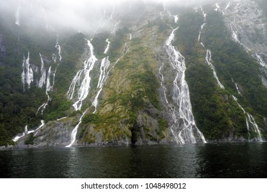 Hundreds of waterfalls flowing from the mountains during the rainstorm in Fiordland National Park, New Zealand