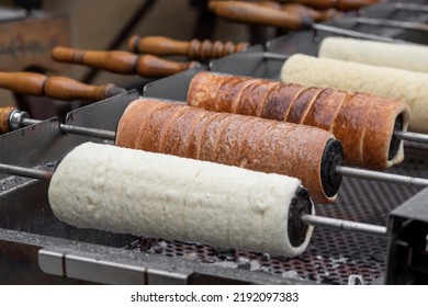 Hungarian chimney cake or kürtőskalács wrapped around a truncated cone–shaped baking spit, and rolled in granulated sugar. It is roasted over charcoal while basted with melted butter, until it's brown