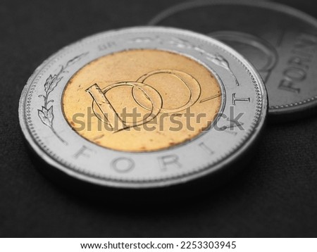 Hungarian coin of 100 forints lies on dark black surface closeup. Money of Hungary. News about economy or currency. Loan and credit. Tax and inflation. Magyar forint. Macro