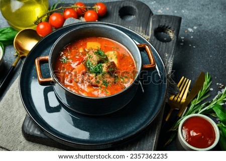 Hungarian dish. Bograch with veal and chili pepper. Close up. On a dark stone background.