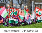 Hungarian flags and cockade. Tricolor rosette is the symbol of the Hungarian national day 15th of march. Symbol of the Hungarian revolution of 1848. Selective focus.