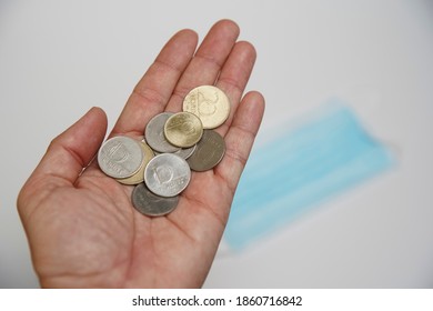 Hungarian Forint Money Coins In A Man 's Palm. In The Background Is A Medical Mask.