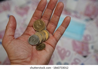 Hungarian Forint Money Coins In A Man 's Palm. In The Background Is A Medical Mask.