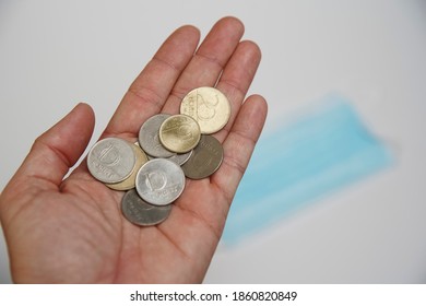 Hungarian Forint Money Coins In A Man 's Palm. In The Background Is A Medical Mask.