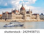 The Hungarian parliament building on the banks of the Danube with a passing excursion boat