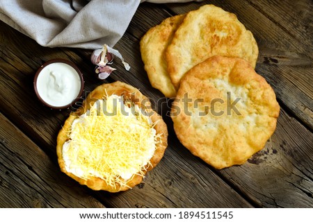Hungarian street food - langos.  Flatbread with sour cream-garlic sauce and cheese