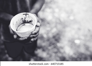 Hunger Boy In Africa.Homeless Boy.Beggar Boy With Empty Cup On Street.black And White.