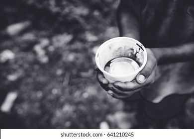 Hunger Boy In Africa.Homeless Kid.Beggar Boy With Empty Cup On Street.black And White.food Supply Shortage.Indian Poor Boy With Cup For Beggar For Money.inflation Money Crisis.homeless Refugee Child.