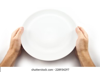 Hunger concept. Man holding empty plate waiting for food isolated on white from top view.
