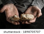 Hunger concept. Pieces of bread in the hands of a man. Poverty.