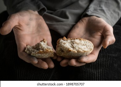 Hunger concept. Pieces of bread in the hands of a man. Poverty.