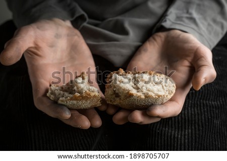 Hunger concept. Pieces of bread in the hands of a man. Poverty.