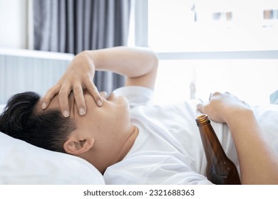 Hungover male suffer from headache after waking up in morning,drank too much last night,Drunk middle aged man having a hangover,drinking an excess of alcohol,stay on bed,feeling unrefreshed,discomfort - Powered by Shutterstock