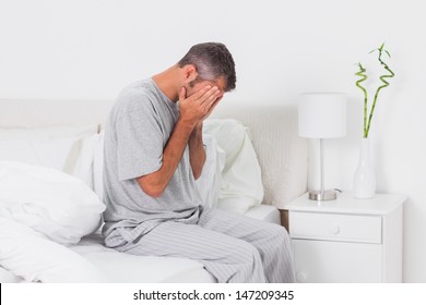 Hungover Man Holding His Head In Bed