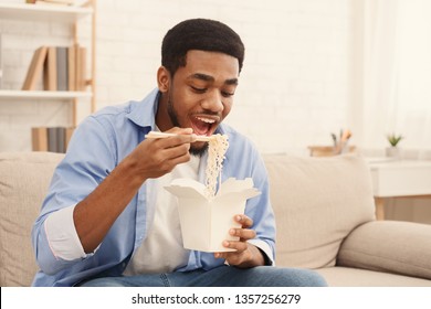 Hungry African American Guy Eating Noodles, Enjoying Asian Food Delivery Service, Free Space