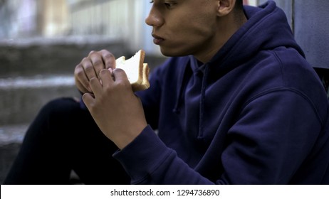 Hungry Afro-american Teenager Eagerly Eating Sandwich, Poor Family, Crisis