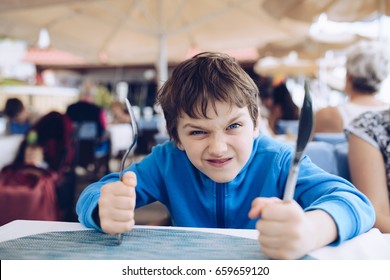 Hungry Angry Little Boy Waiting For His Dinner At Restaurant