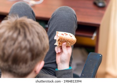 A Hungry Boy Eating A Hot Dog At Home Kid Eats A Hot-dog Sandwich.Indoors Shot.Closeup.