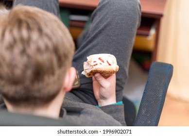 A Hungry Boy Eating A Hot Dog At Home Kid Eats A Hot-dog Sandwich.Indoors Shot.Closeup.