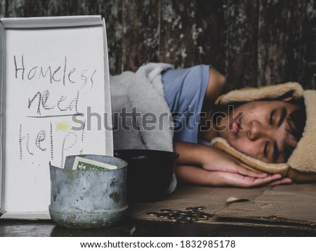 Hungry child lay down on street with hungry and asking help food or money from traveler on street at the city. Unidentified homeless child begging on street. Shelter concept.