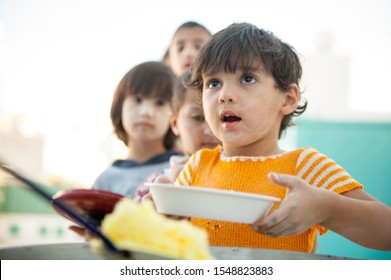 Hungry children being fed by charity