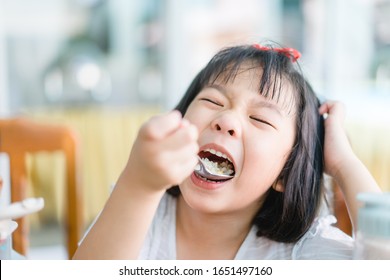 Hungry Face And Enjoy Eating Concept.Little Asian Girl Enjoy Eating With Rice And Vegetable On A Plate In Lunch Time At Home.Asian Kid Girl Holding Spoon With White Rice And Open Her Mouth.