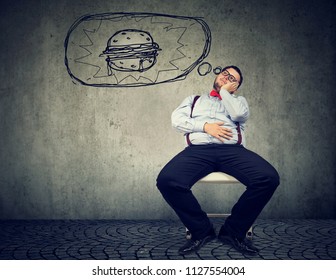 Hungry Fat Business Man Sitting On Chair Dreaming Of A Burger 