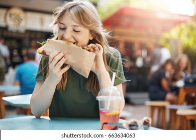 Hungry Freckled Blonde Girl Eating Taco On A Food Court On A Sunny Summer Day In Park.