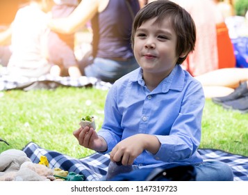 Hungry Kid Eating Fresh Tortilla Wraps With Salmon Mixed Vegetables,Cute  Boy Siting On Rug Having A Picnic In The Park, Kid Eating Mexican Sandwich Food For His Snack.