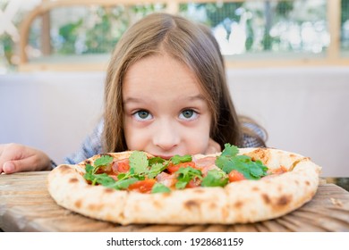 Hungry Kid Girl 5-6 Years Eating Pizza On Cafe Terrace On Sunny Day. Family Having Fun Outside The Restaurant