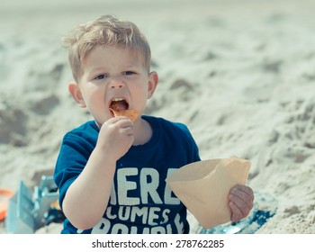 Hungry Kid With Open Mouth Eating Salty Fat Chips Or Junk Food On The Beach